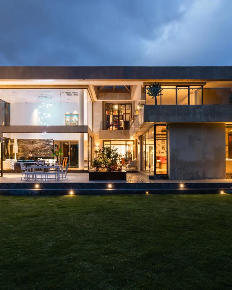 The facade of a contemporary house lit from within at dusk.